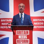 Nigel Farage, speaking behind Union Jack